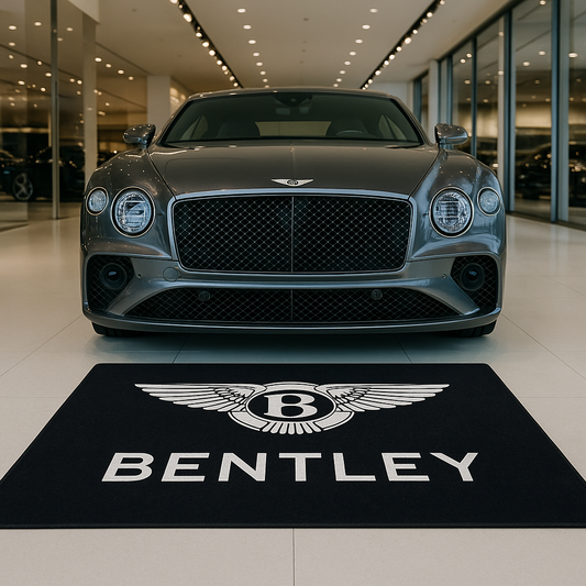 Premium Bentley wings logo floor rug, 150x220cm (approx. 5x7ft), with anti-slip backing displayed in a luxury British car showroom.